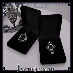 Black crystal Gothic Lolita brooch collection displayed with silver filigree crown jewelry on black velvet boxes