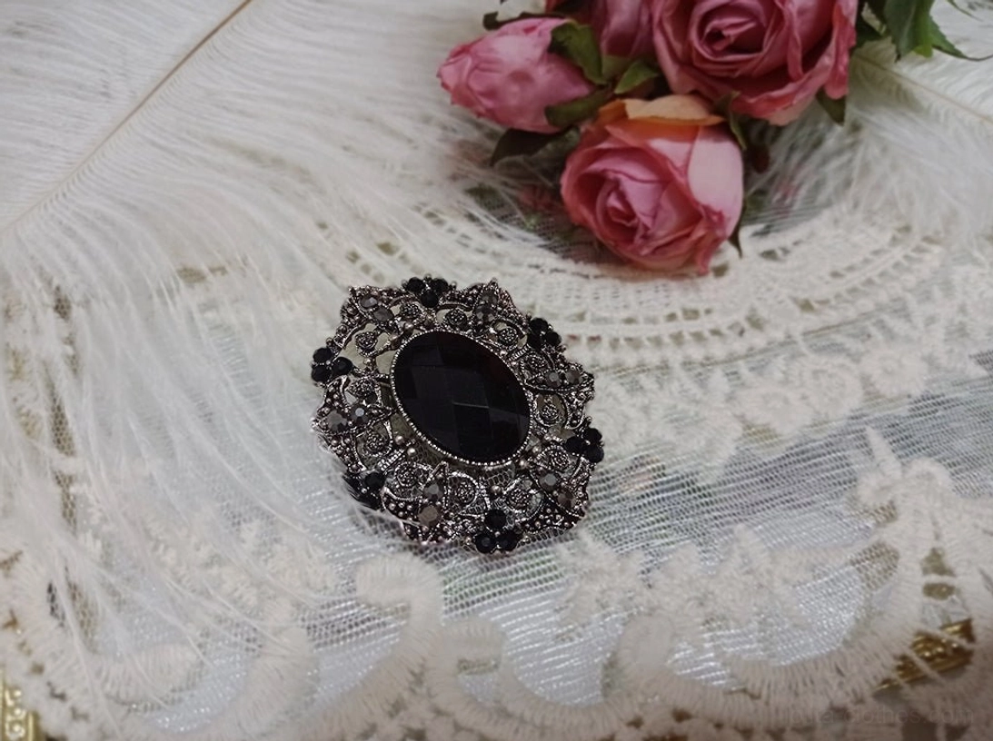 Black diamond-inspired vintage Lolita brooch with antique silver-tone frame, dark center, and surrounding gem details on white lace
