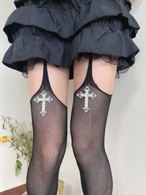 Close-up front view of black fishnet pantyhose with sparkling silver cross pendant decorations and garter strap detail Gothic Lolita hosiery