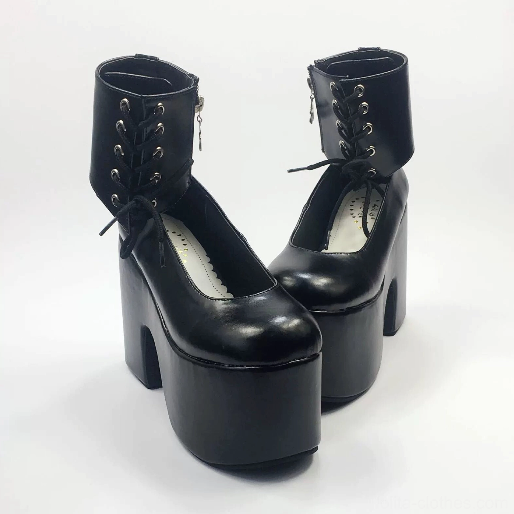 Black glossy lolita platform ankle boots with metal lace eyelets and thick block heel, three-quarter front view showcasing round toe and decorative lacing details
