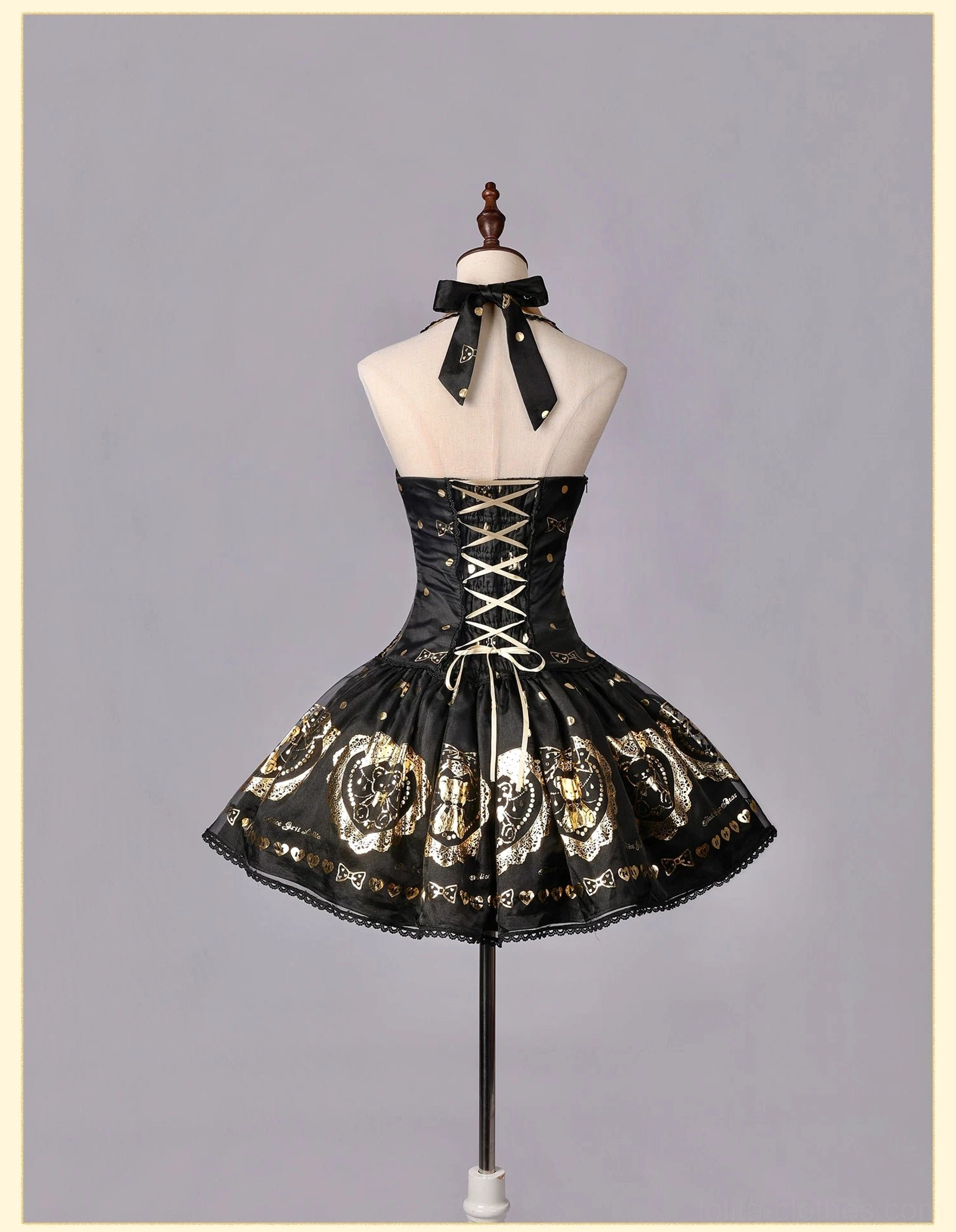 Corset-style black and gold bear print lolita dress on dress form showing lace-up back corset design, voluminous flared skirt with gold bear prints and delicate lace hem trim