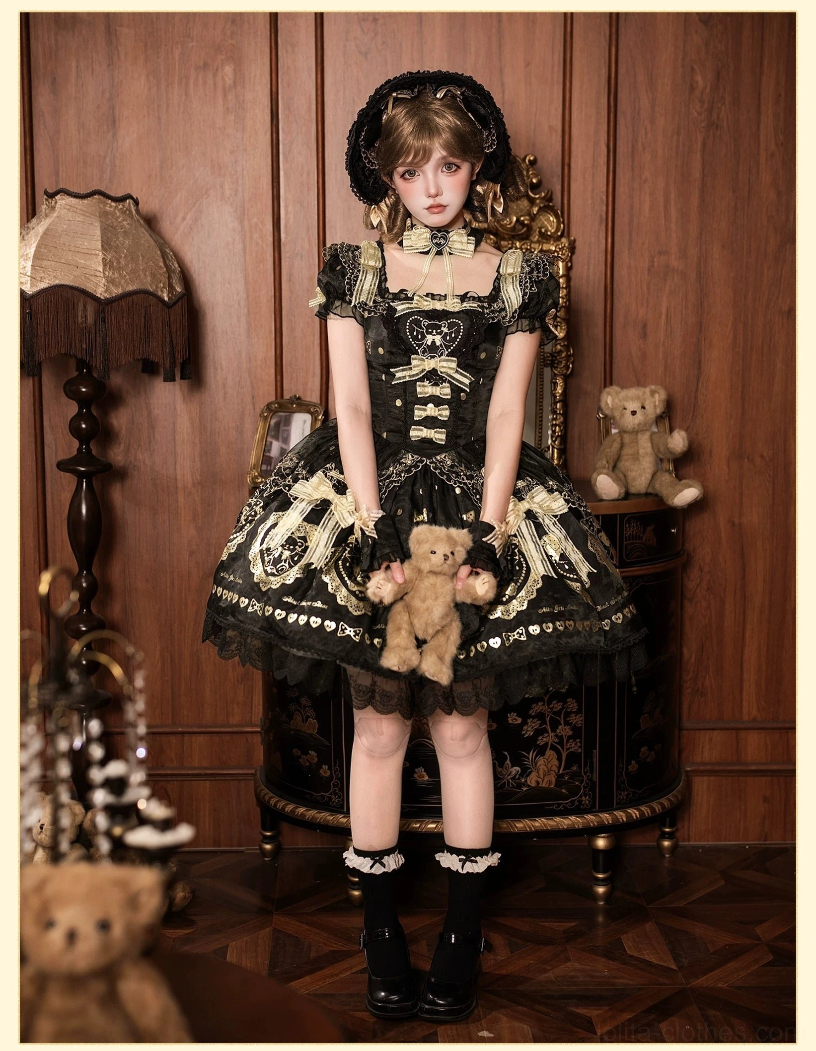 Flat lay photography of black and gold bear print lolita dress showing overall fabric pattern, hot-stamped bear and heart designs, lace details, and construction quality
