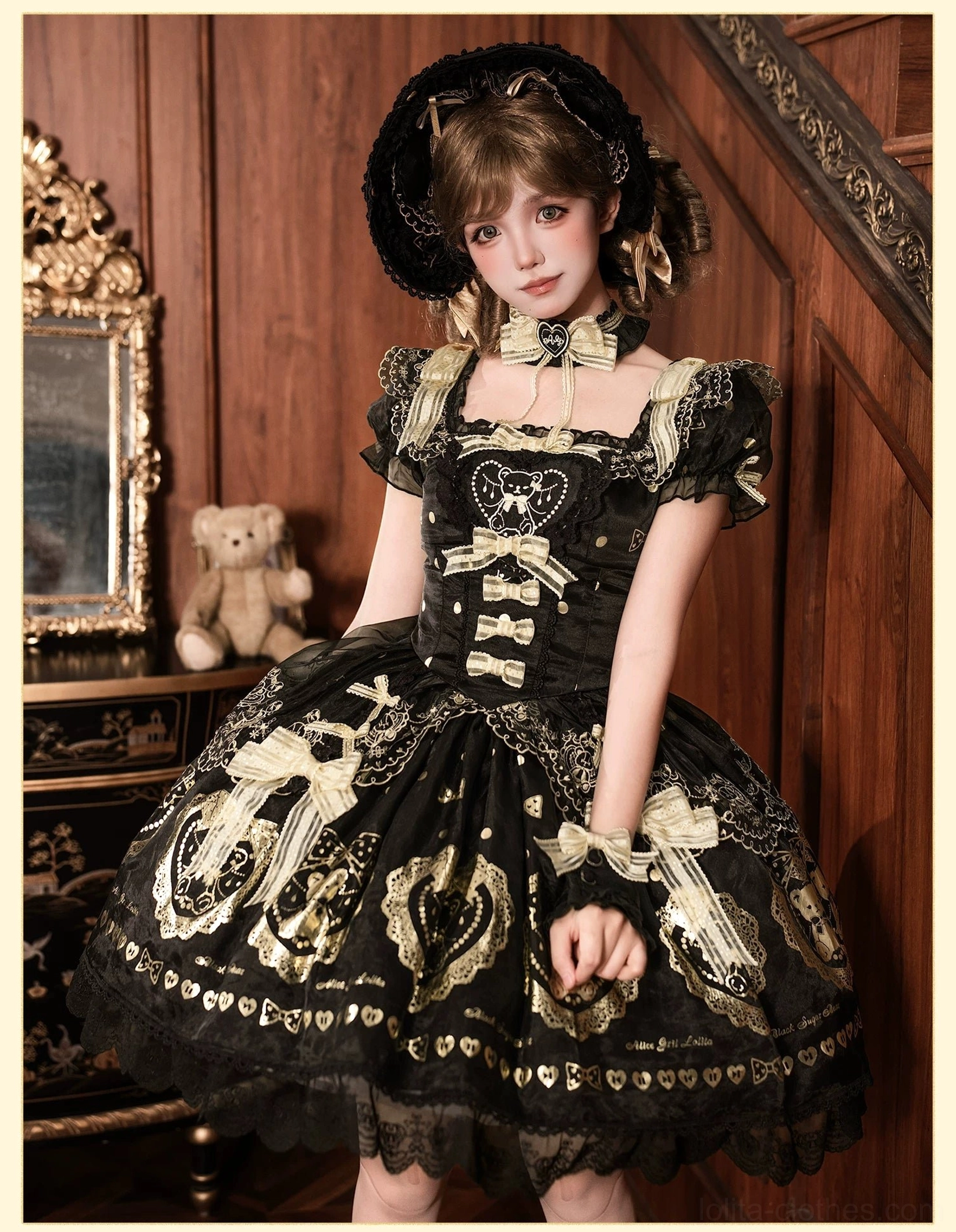 Two styled models in black and gold bear print lolita dresses positioned in vintage interior, showing how dress coordinates with lolita accessories, demonstrating recommended styling and pairings