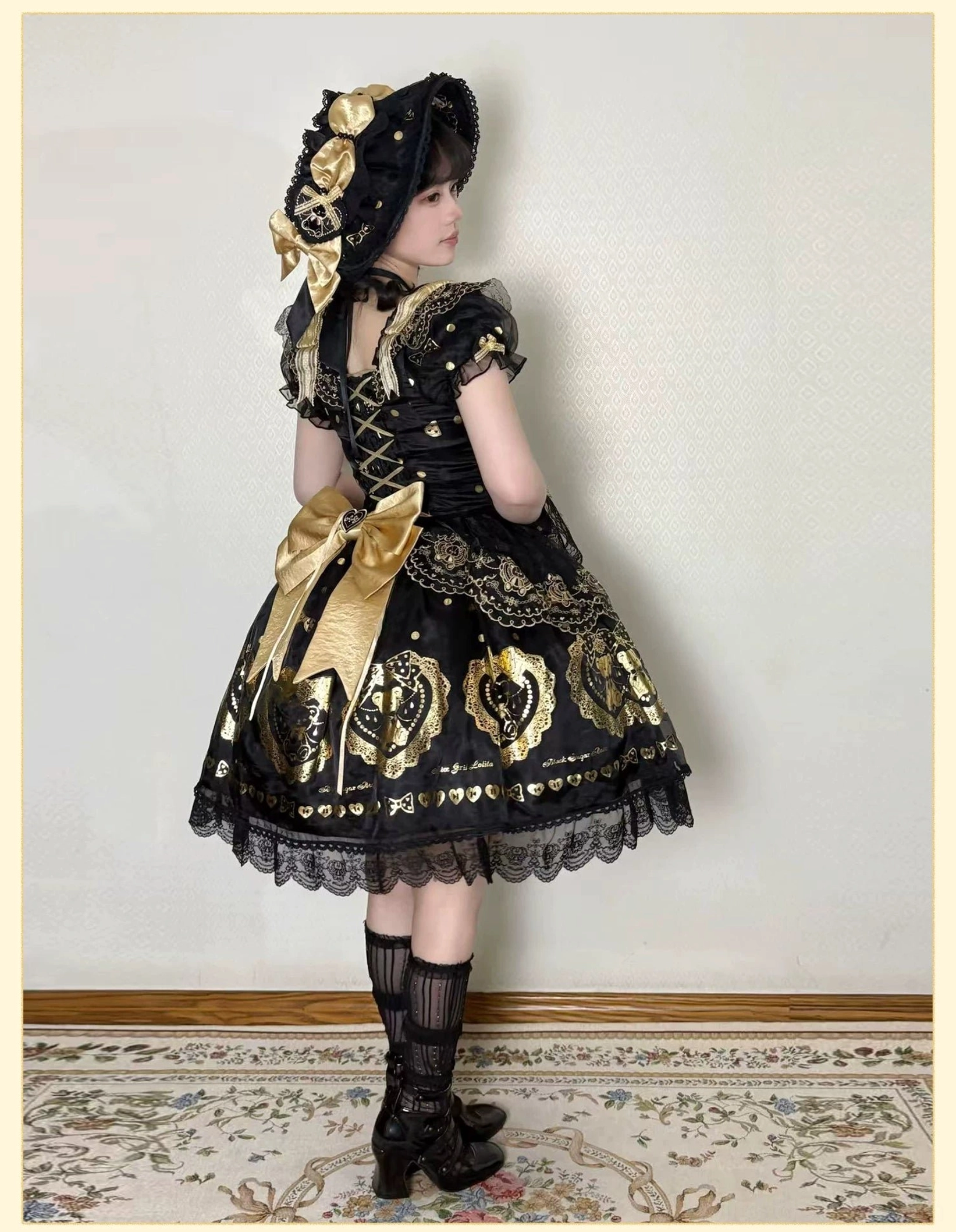 Waistline and skirt construction detail of black and gold bear print lolita dress showing structured waist definition, voluminous skirt gathers, lace hem trim, and dress proportions