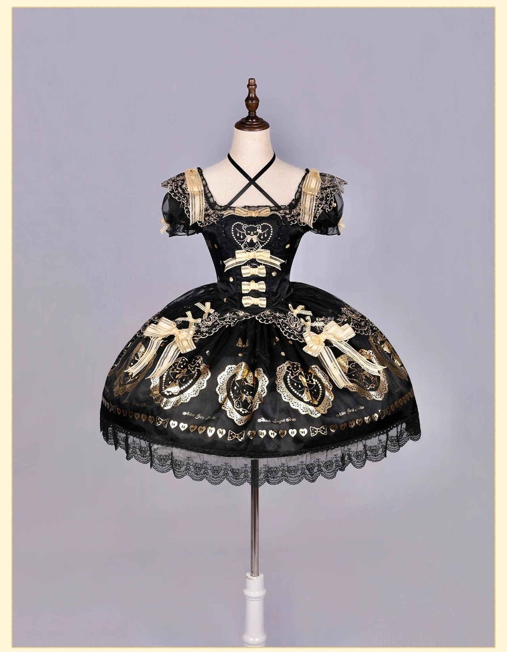 Off-shoulder cross-strap black and gold bear print lolita OP dress on dress form featuring cap-sleeve off-shoulder design, lace-up front bodice, gold bear print patterns on black fabric