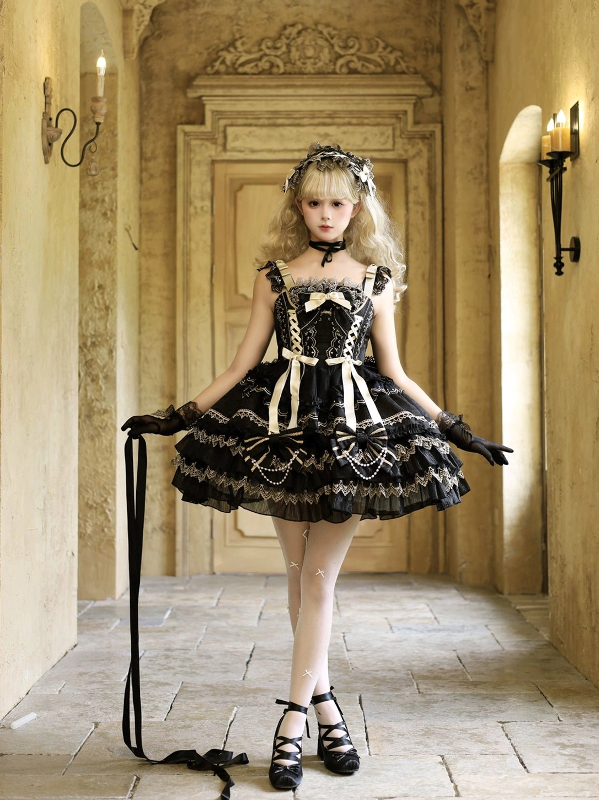 Black and gold gothic lolita jumper dress full body side view with short tiered ruffles front ribbon bows detachable waist straps and black opera gloves