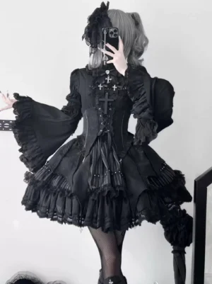Black Gothic Lolita bat-wing skirt set with waist cincher worn by model with gray twin buns, showcasing layered ruffled skirt with cross pendants and detachable hime sleeves