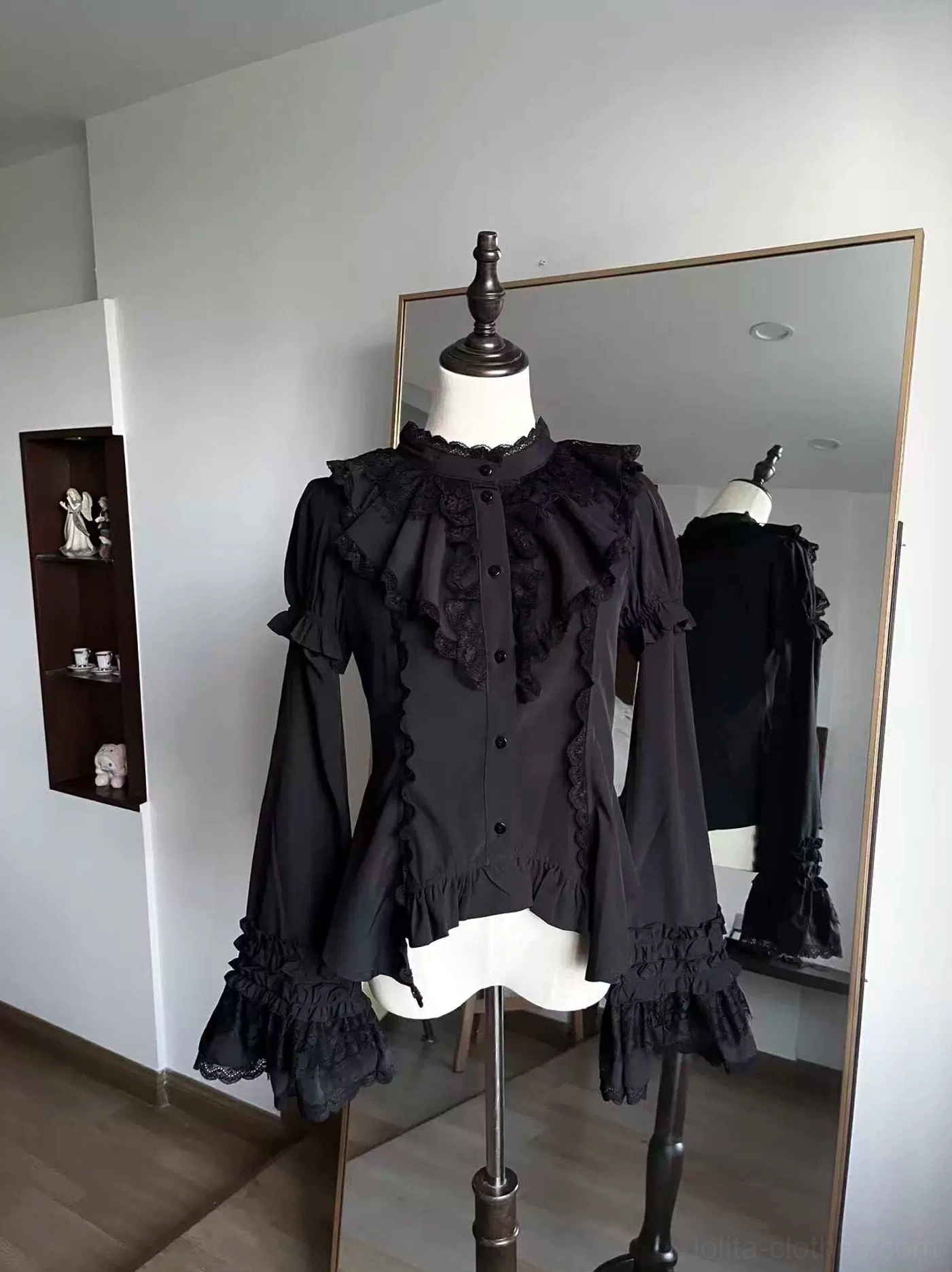 Black gothic lolita blouse front view with ruffled stand collar and flared detachable sleeves on dress mannequin