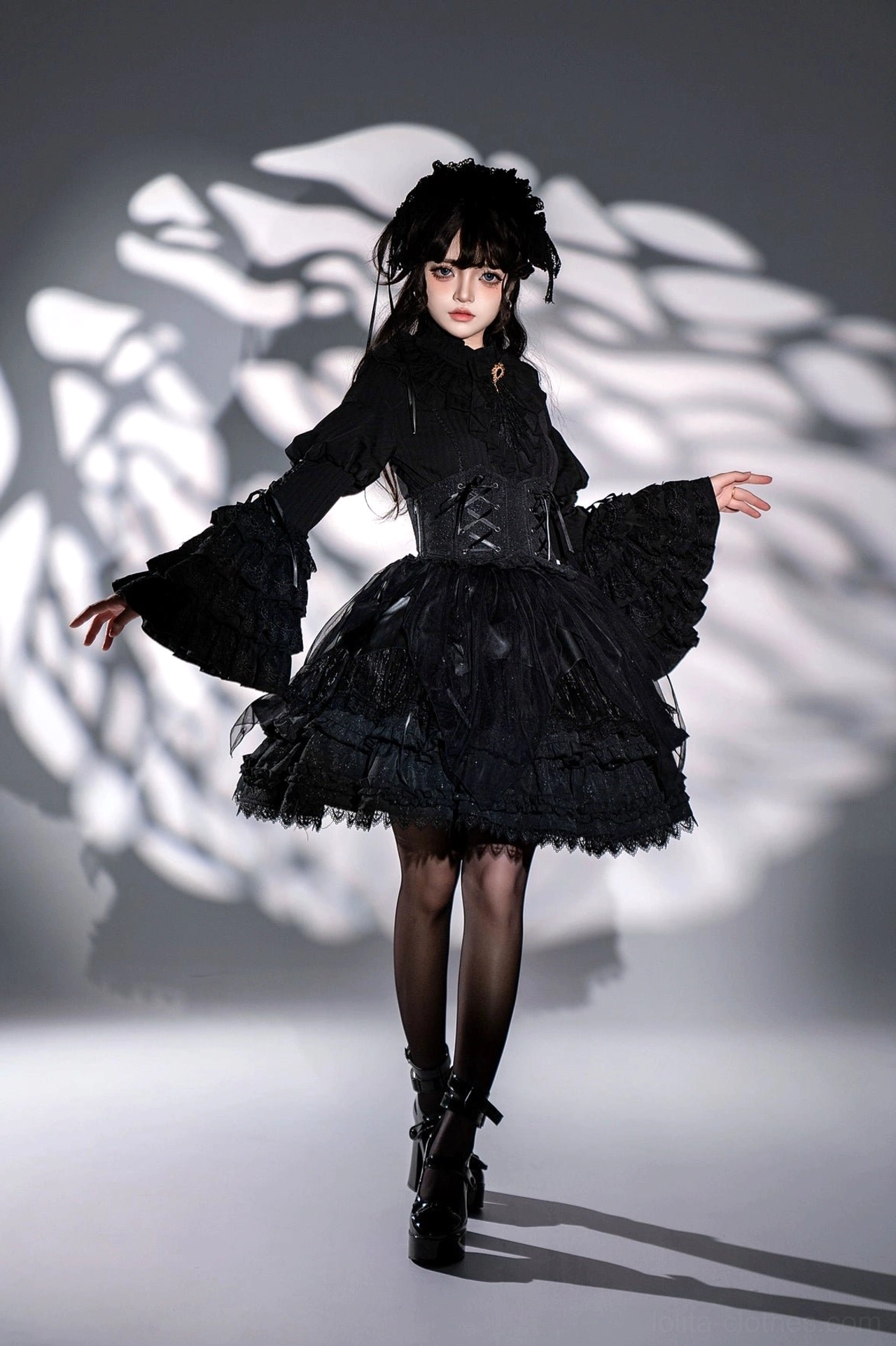 Black gothic lolita dress full-body front standing pose showing fitted corset waist wide flared bell sleeves and short layered ruffled skirt with lace edging