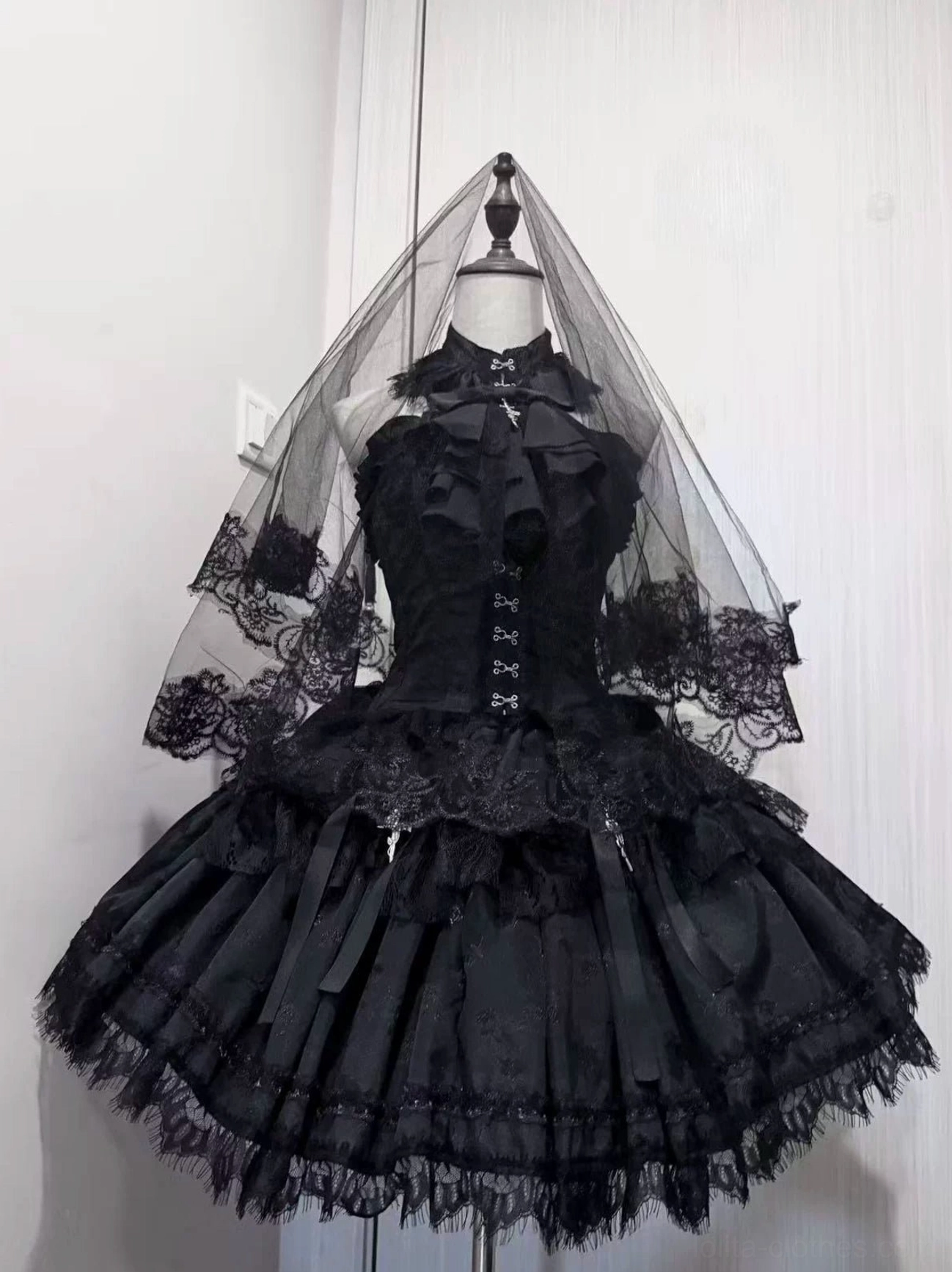 Black gothic lolita fishbone corset and layered mesh skirt set with cross details, front full view on mannequin with lace veil, studio display with white background