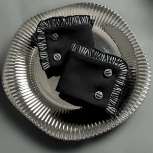 Black gothic Lolita wrist cuffs with silver-white striped ruffled edges and round metal button fasteners top view