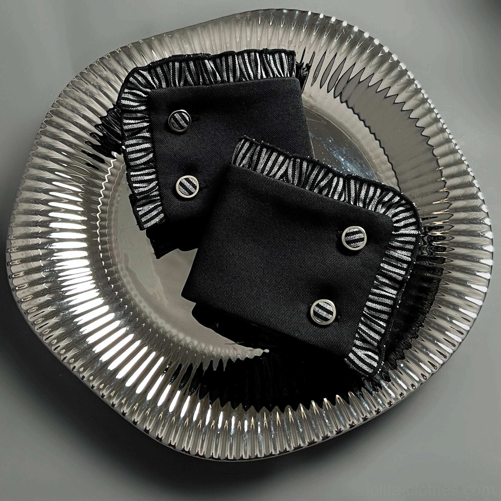 Black gothic Lolita wrist cuffs with silver-white striped ruffled edges and round metal button fasteners top view