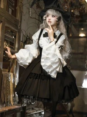 Black Gothic Lolita JSK outfit with tiered ruffled skirt and puff sleeves three-quarter front pose on model wearing witch hat
