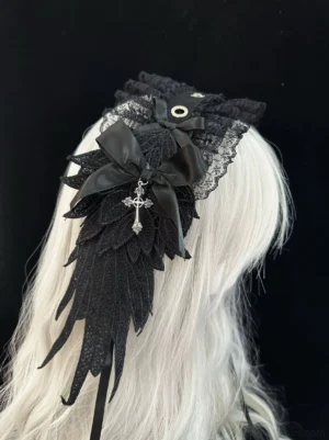 Black Gothic Lolita lace hairband with embroidered wing ornament and cross pendant satin bow, displayed on silver long wig mannequin, back upper side angle view showing detailed lace ruffles and metal eyelet accents