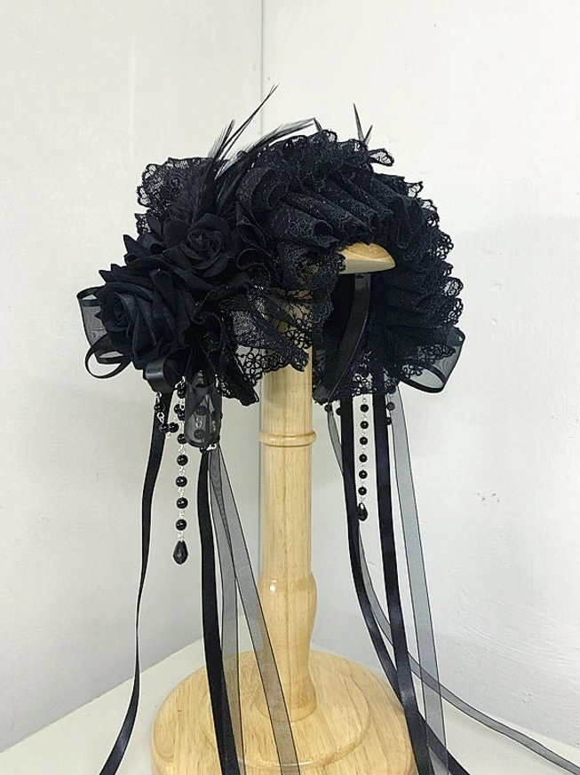 Black gothic lolita lace headdress with silk roses ruffled lace feather accents beaded ribbon tassels wooden display stand front view