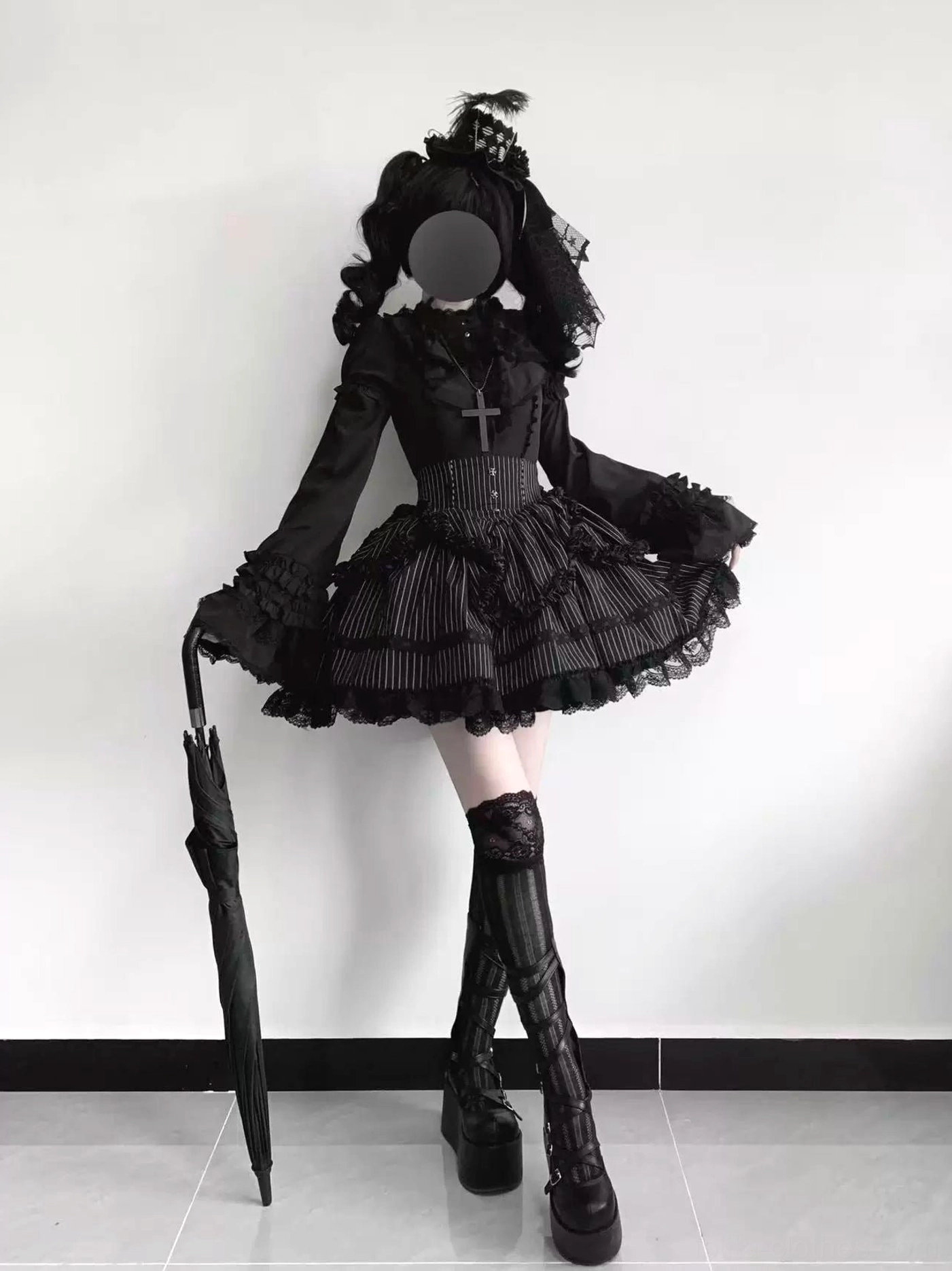 Black gothic lolita mini dress with pinstripe ruffled hem cross pendant and tall platform boots umbrella styling