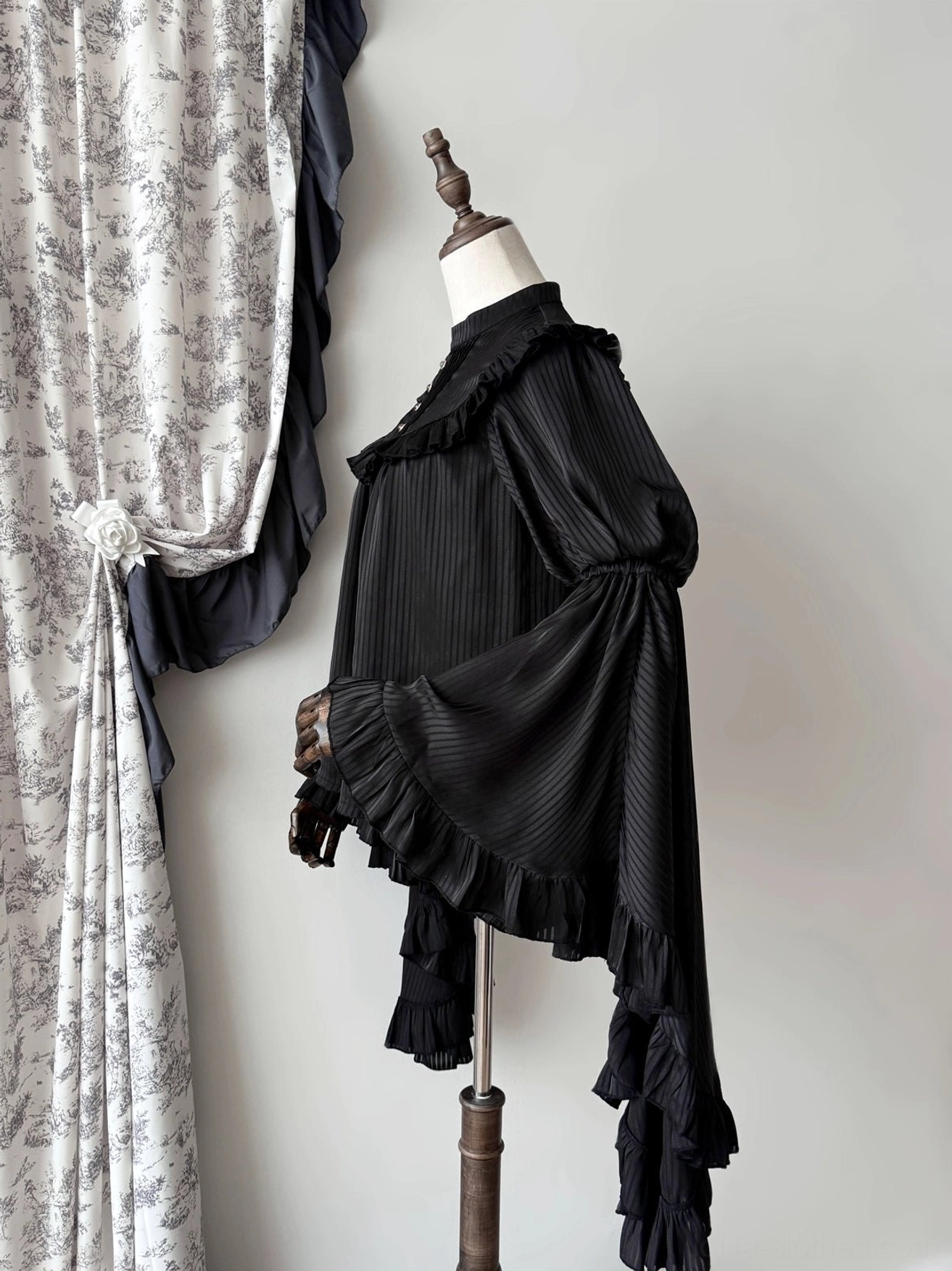 Black gothic lolita blouse right side view showing layered ruffled sleeve hems, back ruffled yoke, and vertical stripe fabric detail