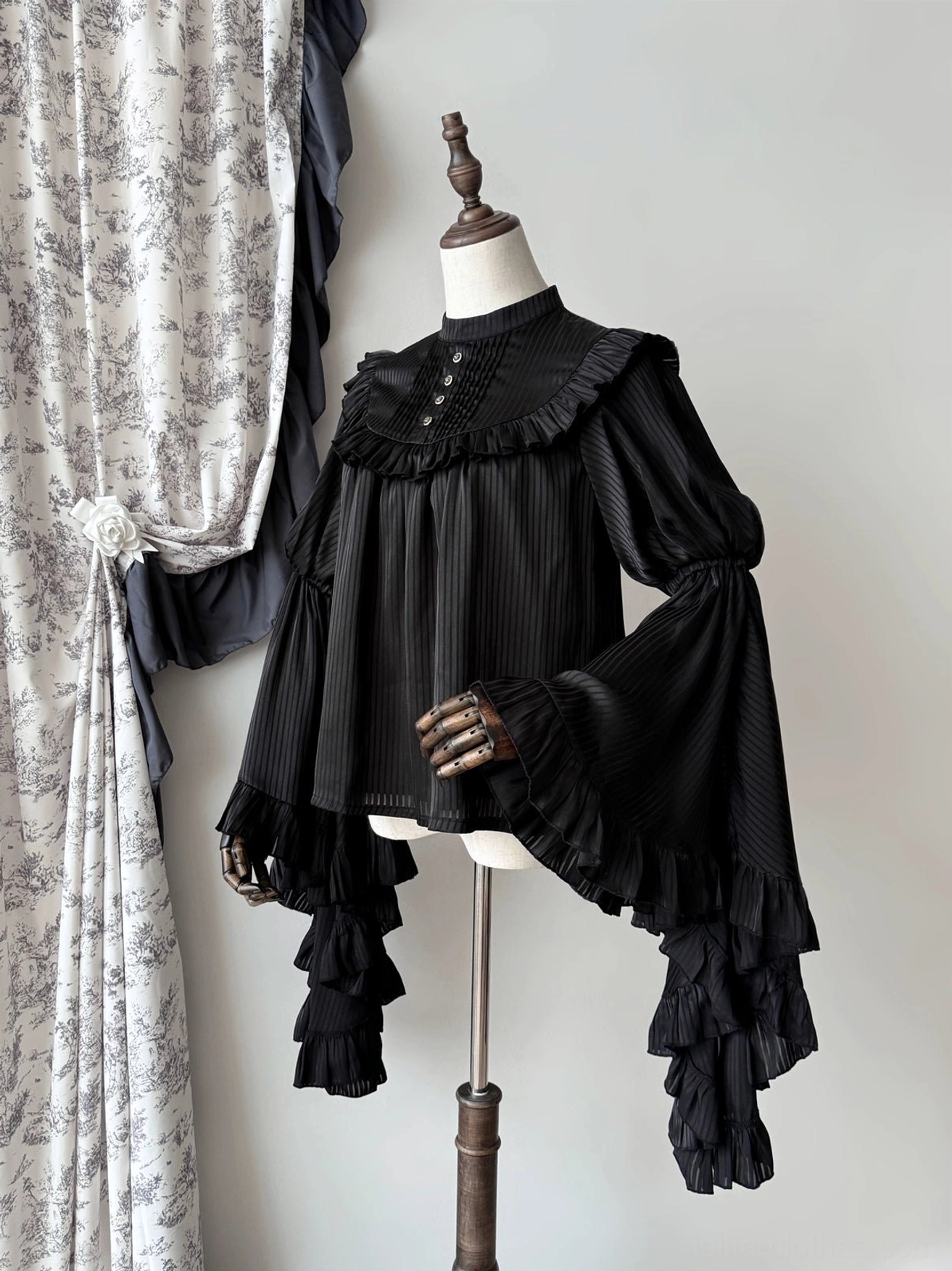 Black gothic lolita princess sleeve blouse left front view with ruffled sleeve trim, pleated fabric, and front collar button decoration