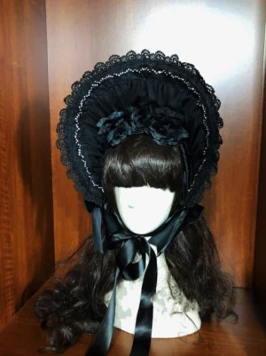 Black gothic lolita velvet half bonnet with beaded lace trim, satin flowers and chin bow - frontal display view on mannequin with dark curly wig