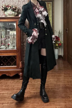 Black Gothic Ouji Lolita wool overcoat front three-quarter view vintage interior setting with ruffled ascot tie striped shorts platform boots