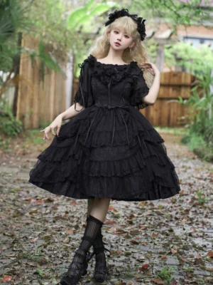 Black gothic princess lolita JSK jumper skirt dress full-body front view with off-shoulder ruffled neckline multi-layered midi skirt outdoor woodland setting