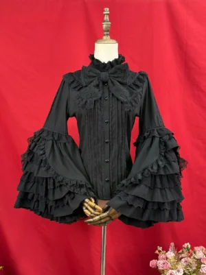 Black classic Lolita puff sleeve blouse featuring layered ruffled hime sleeves with lace trim, detachable bow at ruffled stand collar, front pintuck button placket shown on display mannequin with floral decoration