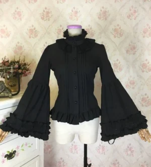 Black hime-sleeve gothic lolita blouse with ruffled stand collar and double-layered trumpet cuffs displayed on dress form with vintage floral wallpaper background, front view showcasing fitted waist silhouette