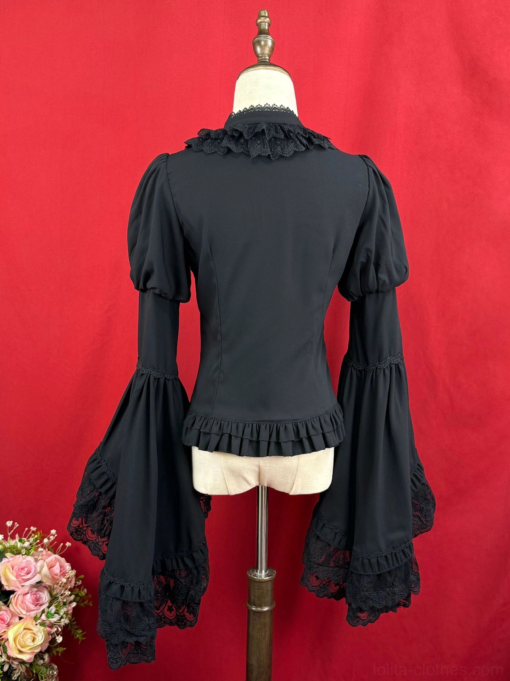 Back view of black classic Lolita blouse displaying ruffled stand collar fitted back cut lace-trimmed trumpet sleeves and bottom ruffled hem