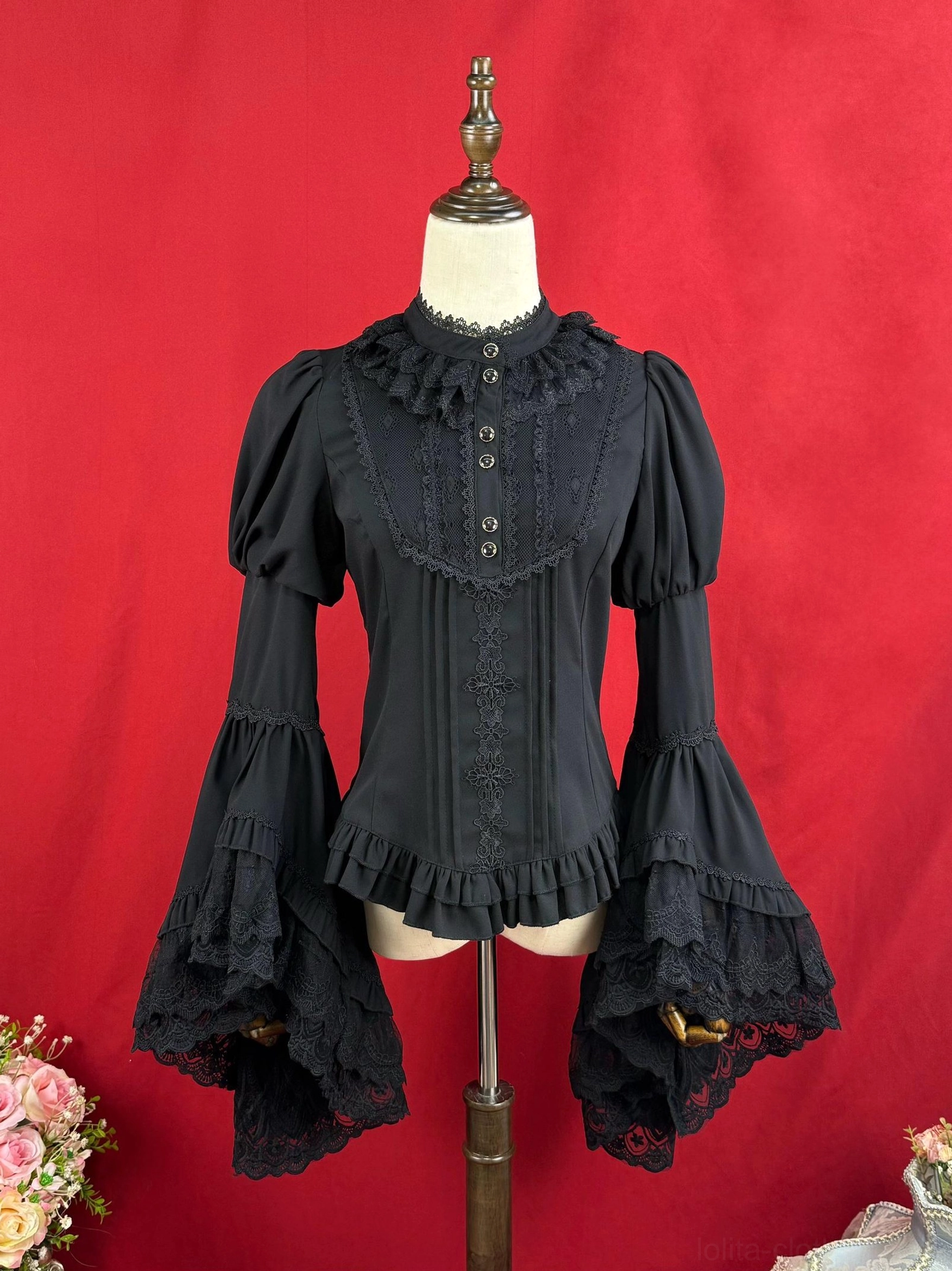 Close-up detail view of black Lolita blouse showing delicate lace decoration on front placket sleeves and neat button construction
