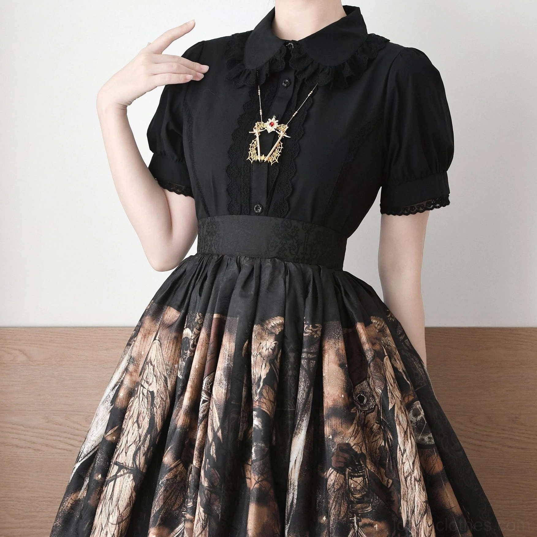 Black vintage Lolita short-sleeve blouse with puff sleeves and lace cuffs paired with printed lolita skirt half-body front wearing shot