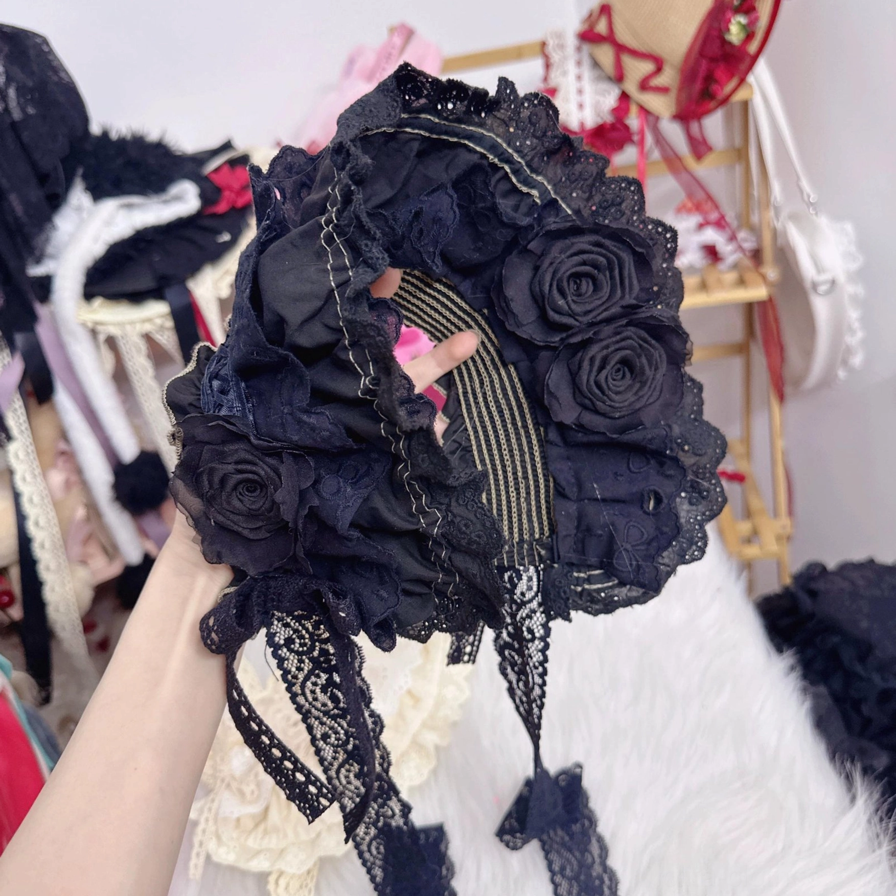 black lolita bonnet held in hand close-up showing striped inner lining long lace chin straps detail