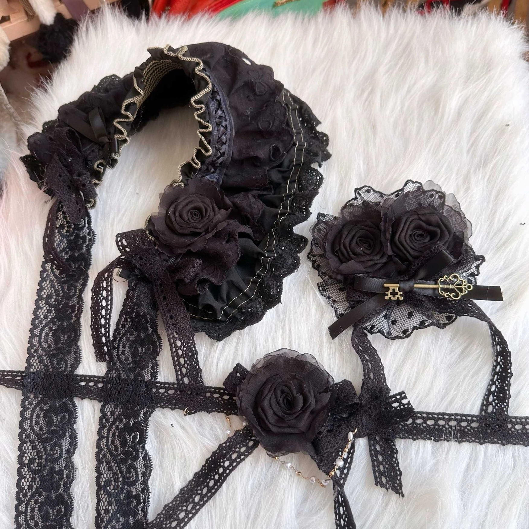 black lolita bonnet and matching rose hair ornaments accessories flat lay white fuzzy mat display