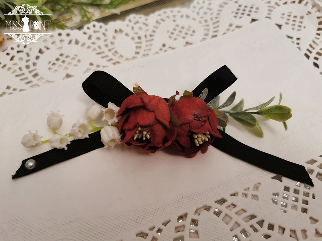 Black lolita bow brooch detail close-up showing lace backing satin ribbon and artificial rose flower embellishment multi-purpose accessory