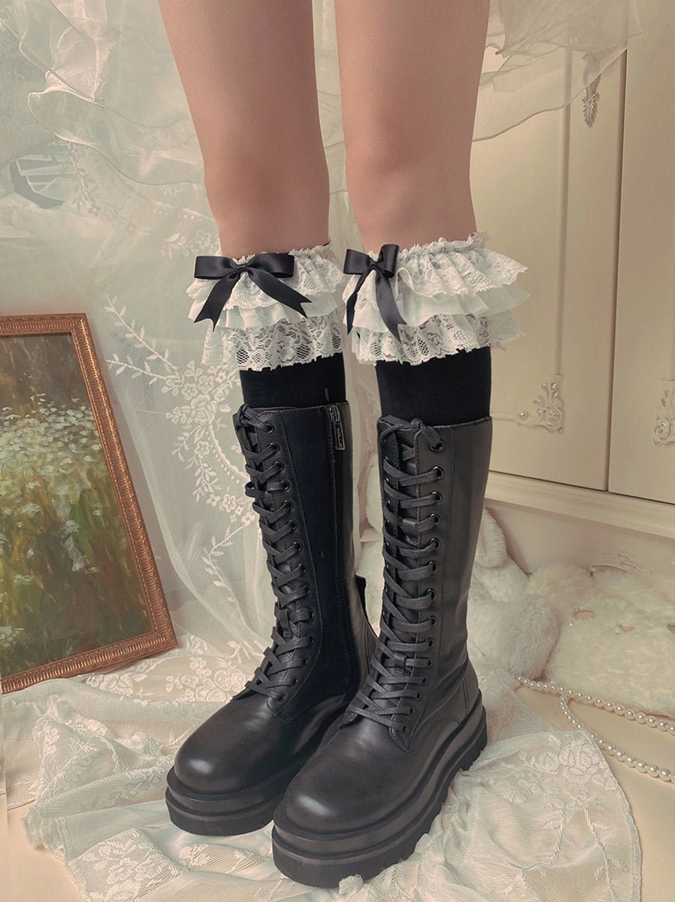 Black cotton Lolita mid-calf socks with white layered ruffled lace trim cuff and black satin bow paired with black platform combat boots vintage interior
