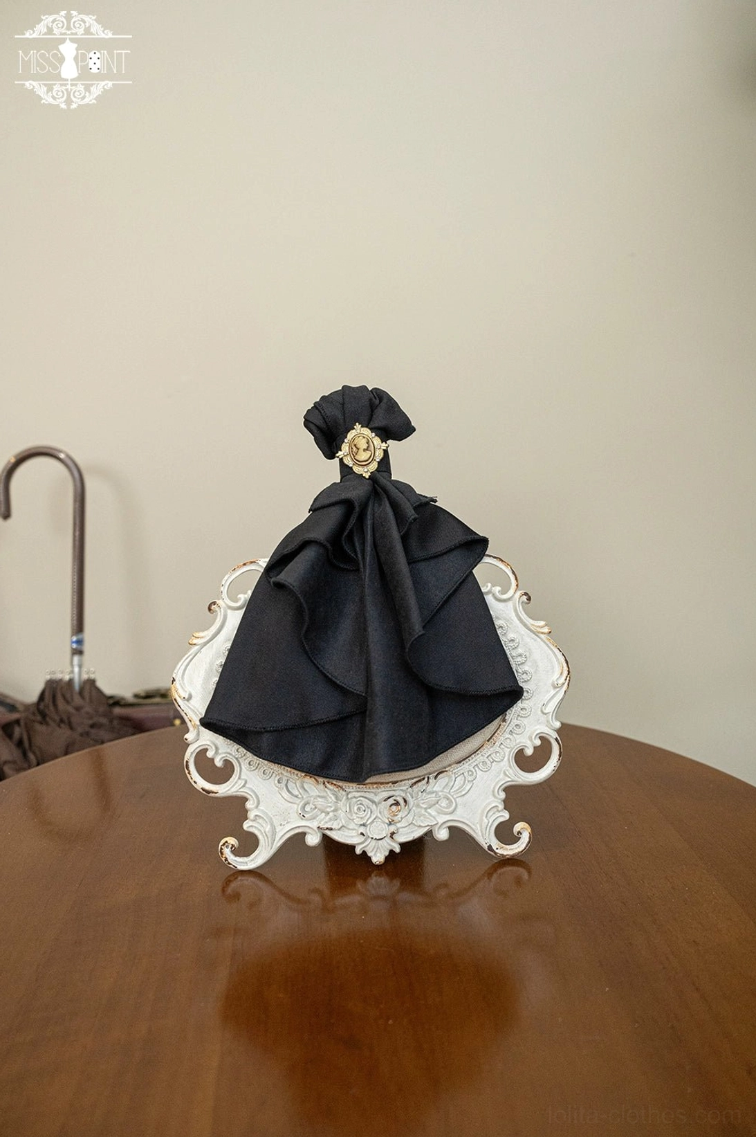 Black lolita bow tie brooch accessory flat lay satin ruffled bow gold round brooch ornament vintage carved porcelain tray product display