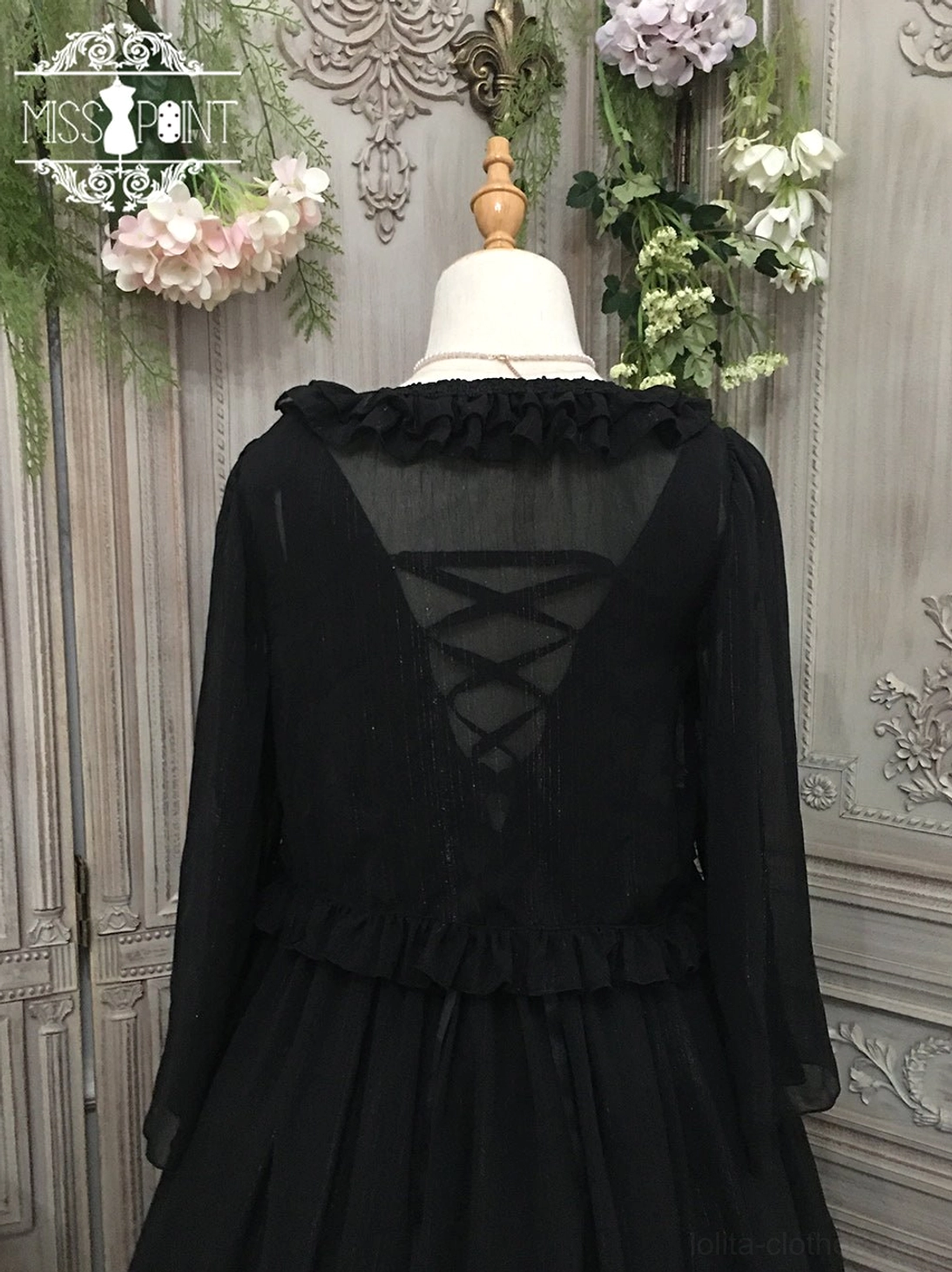 Back view of black lolita cardigan showing ruffled back neckline, delicate crisscross lace-up back design detail, ruffled waist trim, and sheer chiffon construction, displayed on mannequin dress form