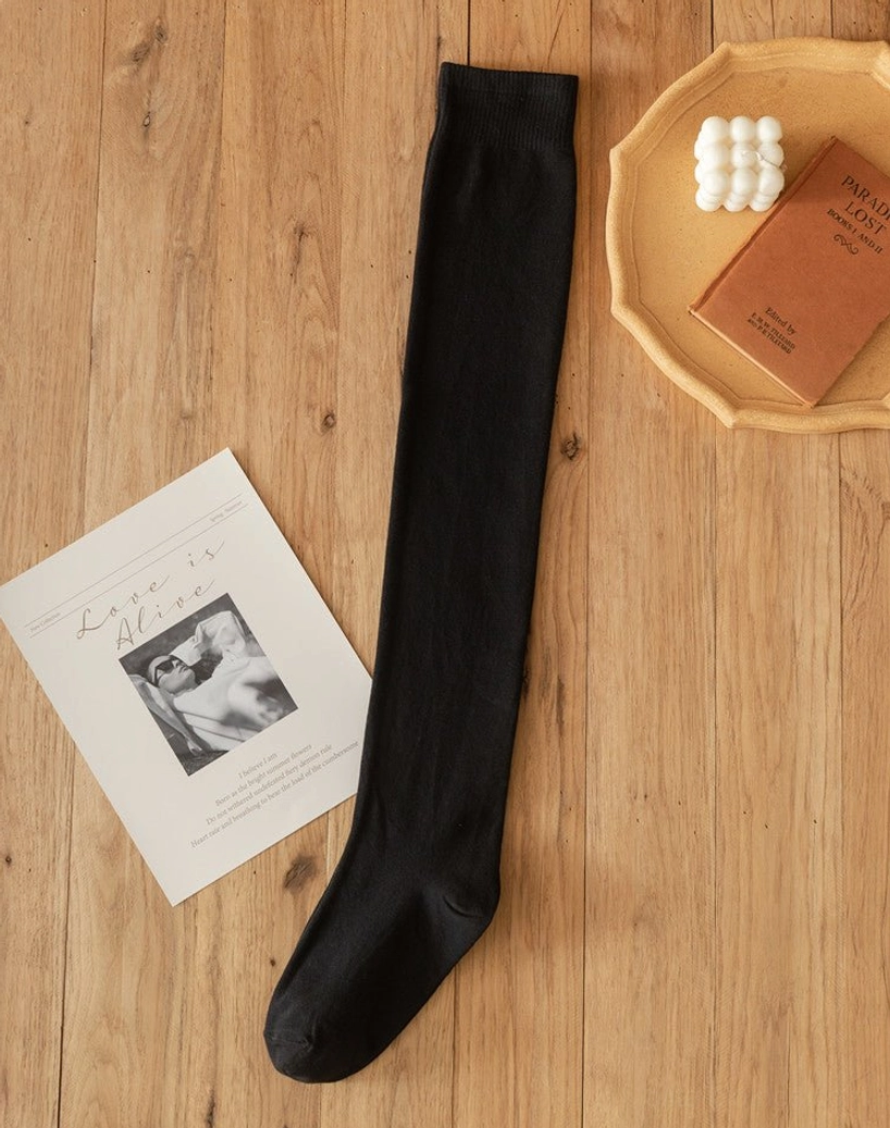 Single black lolita cotton knee stocking flat lay wooden table candle decorative props ribbed knit texture