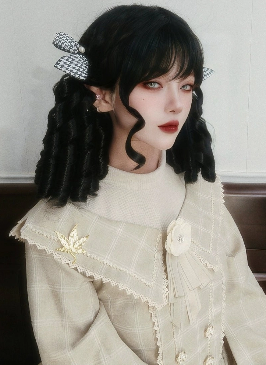 Side front three-quarter view of black roman curl lolita court wig with tight spiral curls and checkered bow hairpins, styled with cream vintage lolita coat and decorative brooch, elf ear accessories