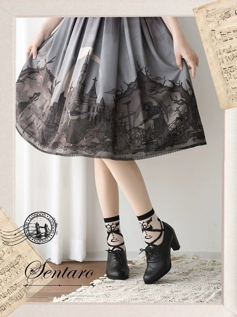Black matte lolita cross-strap ankle heel shoes with brogue perforations and lace-up front detail, styled with grey castle-print lolita skirt and cross-strap printed ankle socks