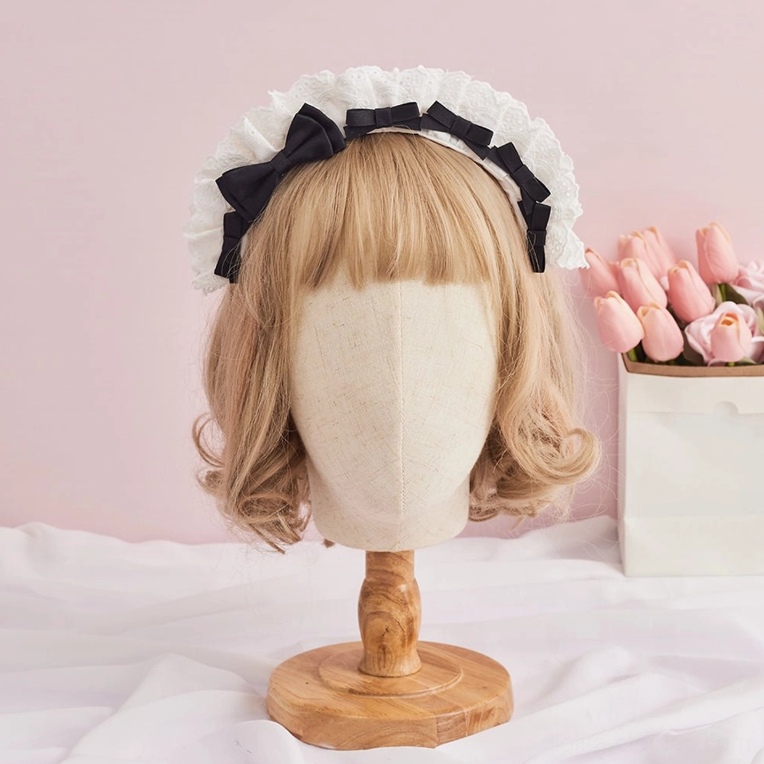 Classic black lolita lace KC headband on blonde mannequin head displaying gothic style with black satin bow and white delicate ruffled lace frame