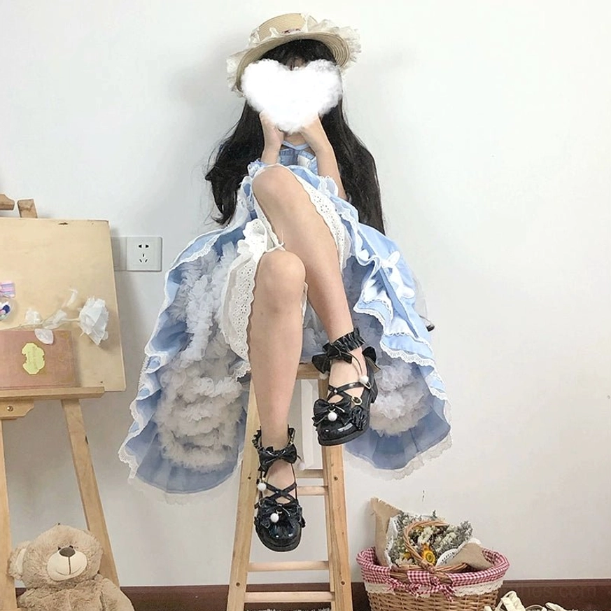 Black Lolita Mary Jane shoes with large back satin butterfly bow and pom-pom accent, high-angle rear shot of model wearing blue-and-white Lolita dress and straw hat