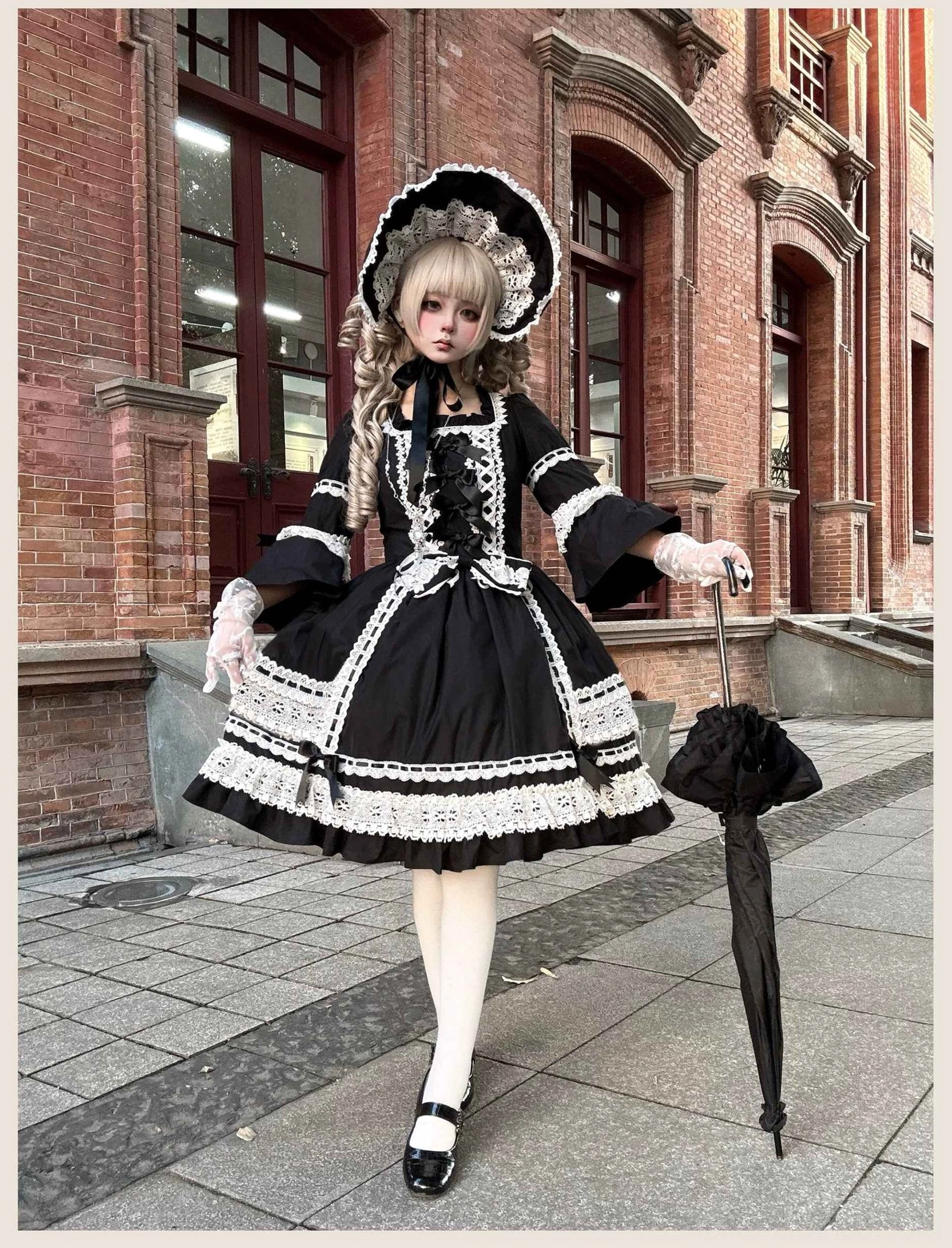 Flat lay display of black old school lolita OP dress showing full length, A-line skirt proportions, lace trims, and overall structured silhouette