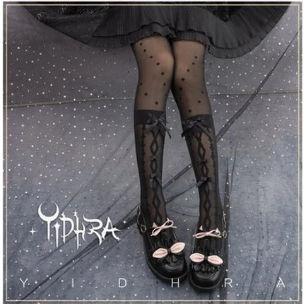 Black lolita over-the-knee stockings with cross-lace design and bow decorations worn with black lolita skirt and mary jane shoes starry backdrop
