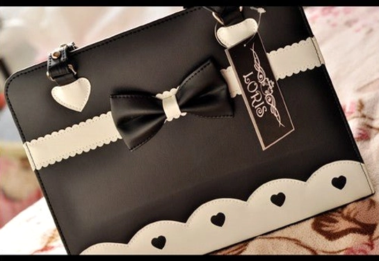 Classic black lolita shoulder bag with bow ornament white heart hardware scalloped trim overhead view