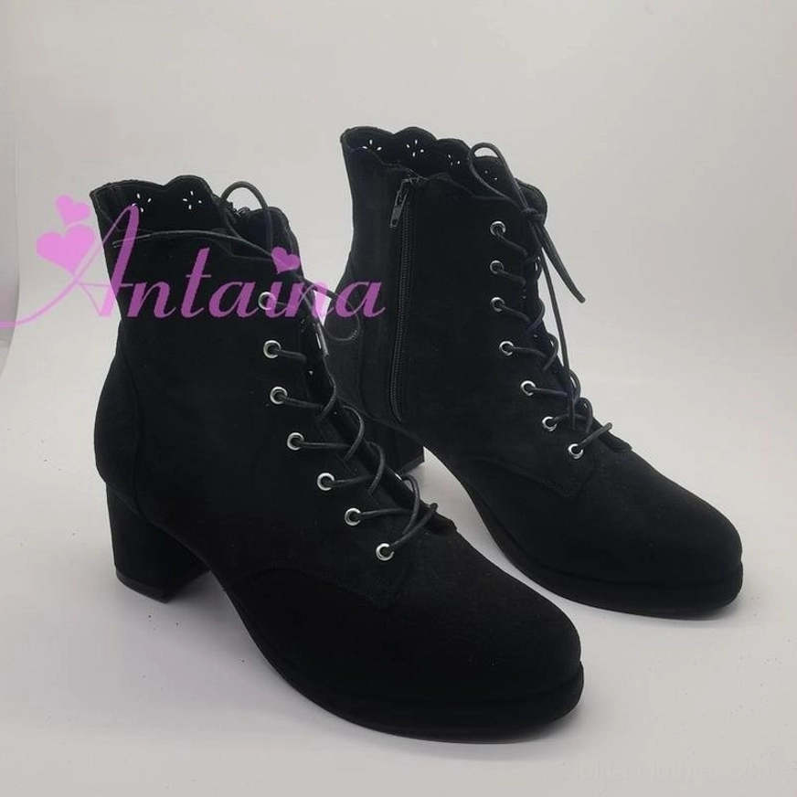 Front three-quarter display of black suede Lolita boots pair featuring metal lace-up eyelets, functional side zipper detail, petal-shaped topline collar, and branded design construction