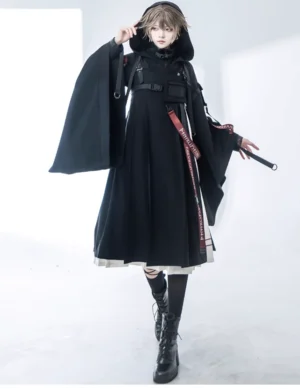Alternative fashion model wearing complete black lolita tactical coat ensemble with red webbing details and black martin boots full-body front view