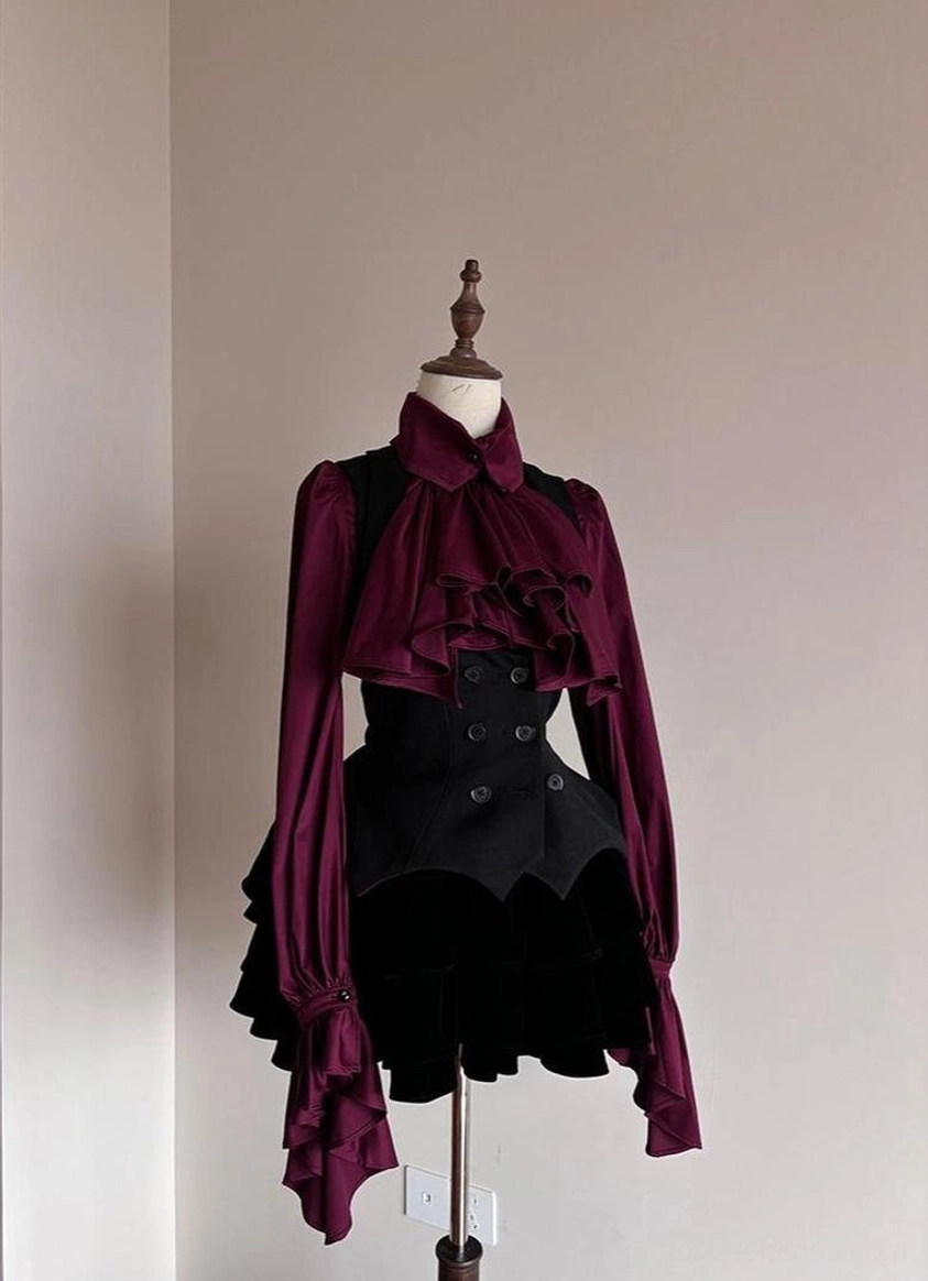 Gothic Lolita two-piece coordinated outfit showing wine-red ruffled long-sleeve blouse paired with fitted black waistcoat and black ruffled shorts with bat hem tail, right three-quarter view