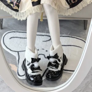 Black patent leather Lolita winter boots with plush turn-down collar and black pompom bow worn with white sheer stockings and lace-trimmed skirt