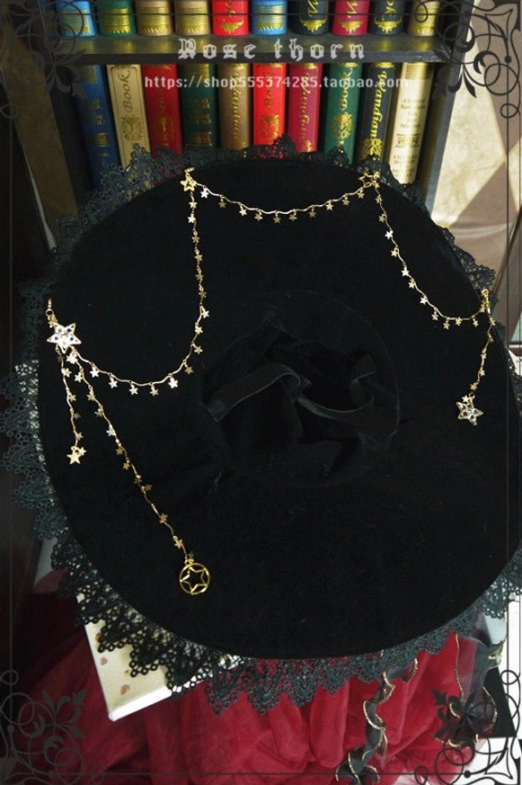 Overhead top-down view of wide-brim black velvet lolita witch hat with gold star-shaped metal chain decoration and lace brim edge