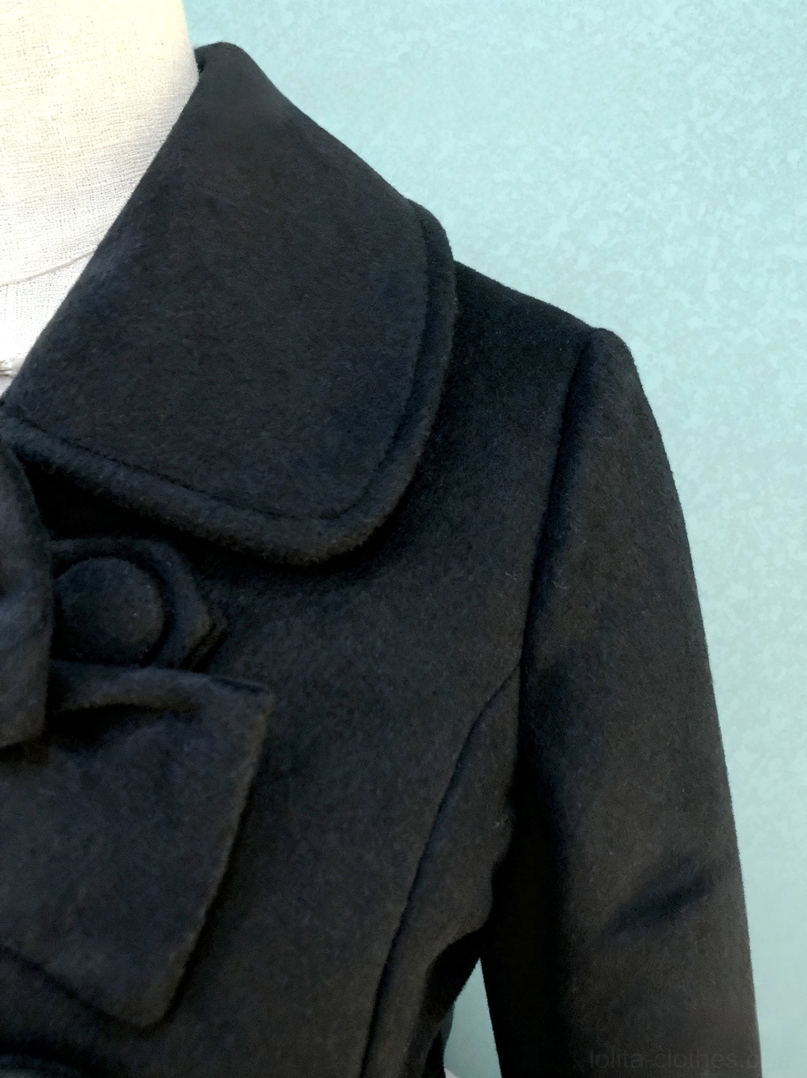 Black Lolita coat shoulder collar close-up notched lapel fabric bow round button smooth wool texture